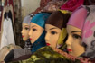 A line of plastic heads modelling headscarves or hijabs sits on a table in a small shop in Fez, Morocco.