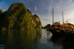 Tourist cruise boats collect for the night near the limestone cliffs of Ha Long Bay, Vietnam