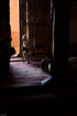 A priest sits in the dim light near an open door inside a rock-cut church near Wukro, Ethiopia.