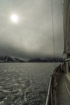 A pale weak sun shows through a layer of overcast offshore from Spitzbergen