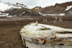 A decaying water boat, used for storing fresh water, lies abandoned on the beach on Deception Island